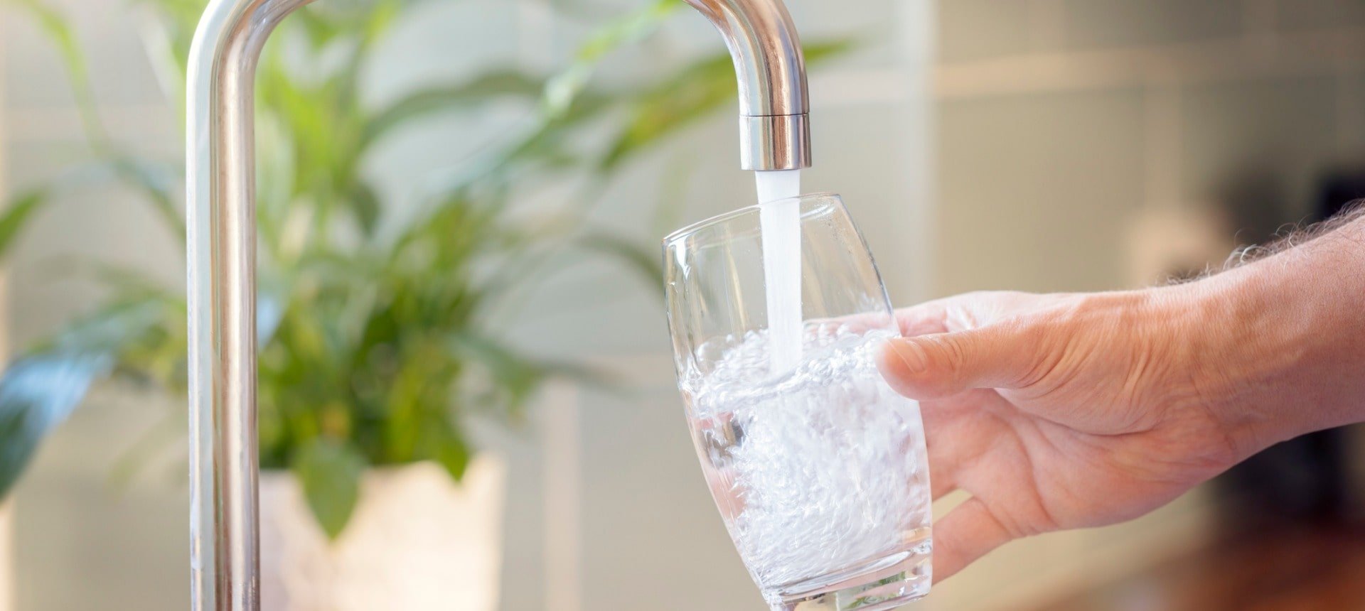 filling-up-a-glass-with-drinking-water-from-kitchen-tap-picture-id1204637747-min