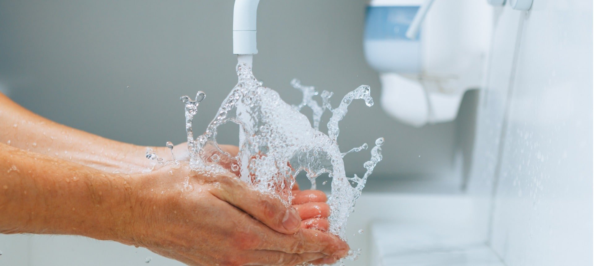 hands-under-the-faucet-with-splashing-water-picture-id1290412318-min