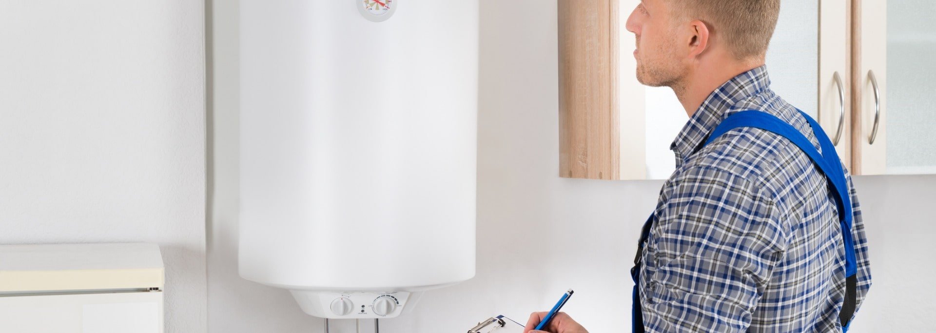 man-with-clipboard-while-looking-at-electric-boiler-picture-id516146516-min