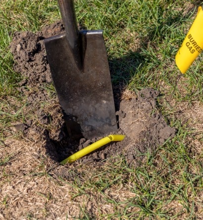 damaged-plastic-natural-gas-line-from-digging-hole-in-soil-of-yard-picture-id1179190501-min